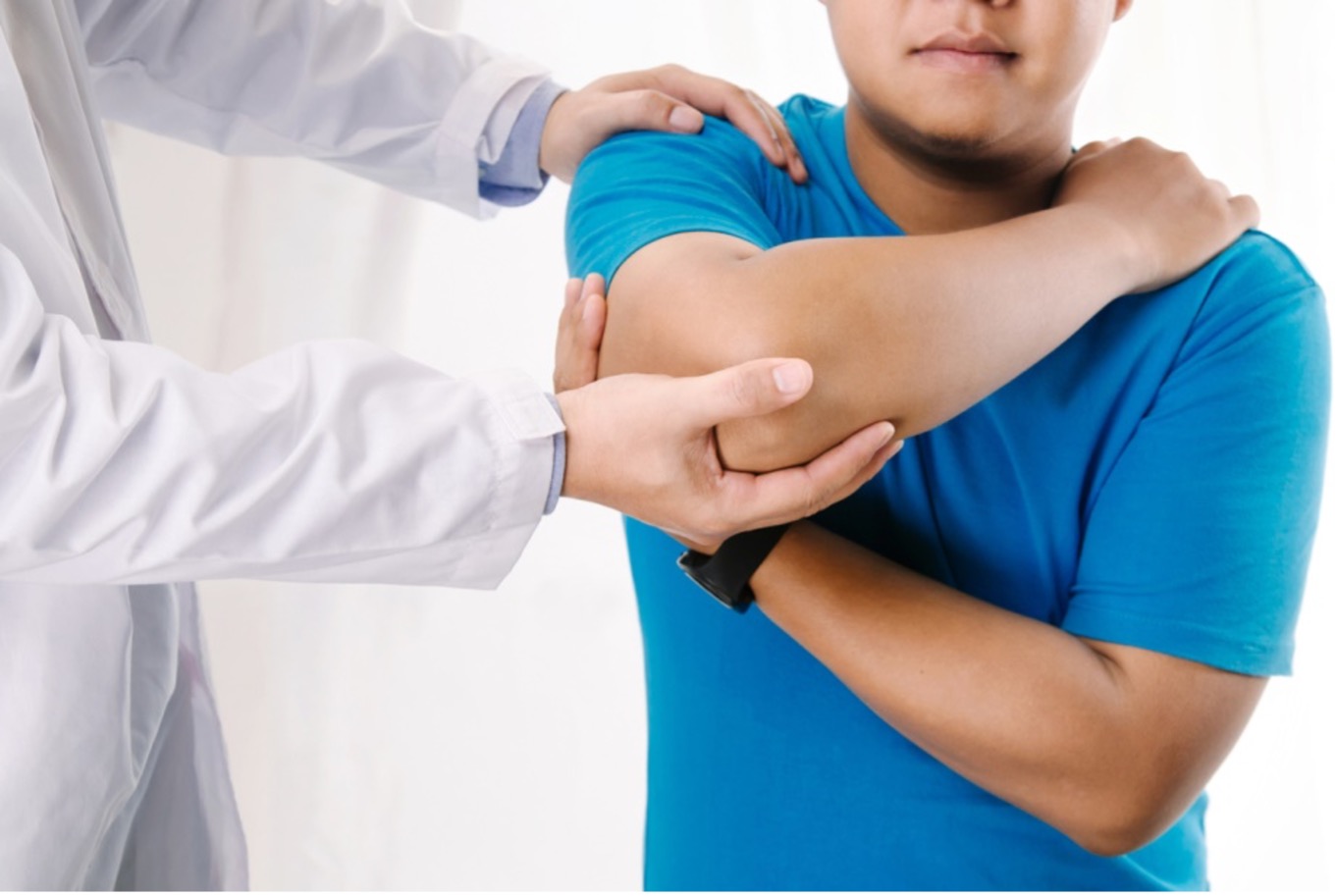 doctor adjusting arm of person holding their shoulder