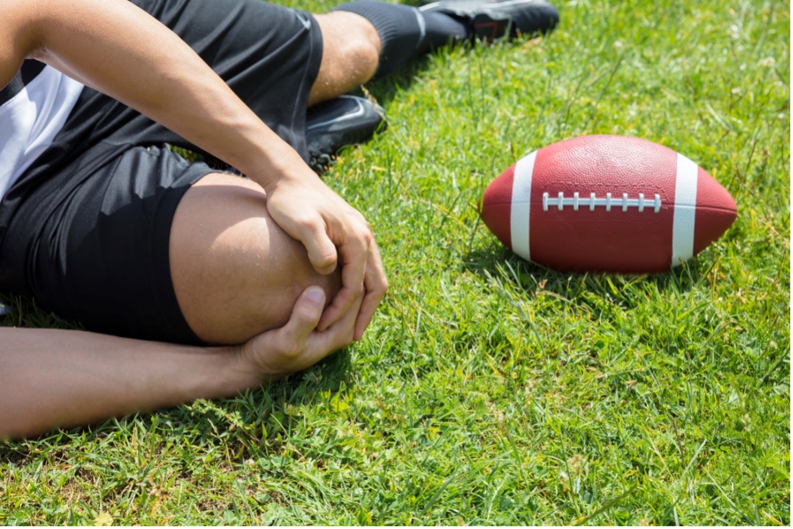 person holding their knee, sports injuries