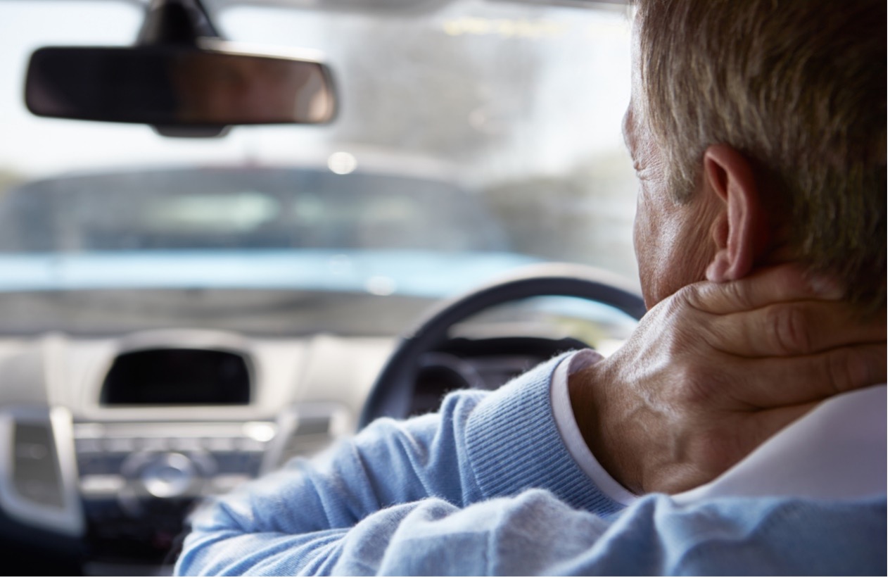 A person with his hand on his neck, whiplash