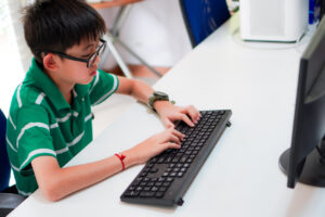 A child using a keyboard, Back-to-School: A Key Time to Prevent Back Pain in Children
