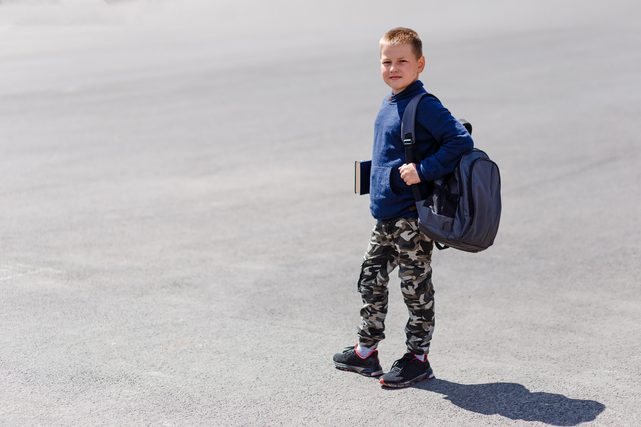 A child with a backpack, Understanding the Risks: What Causes Back Pain in Kids