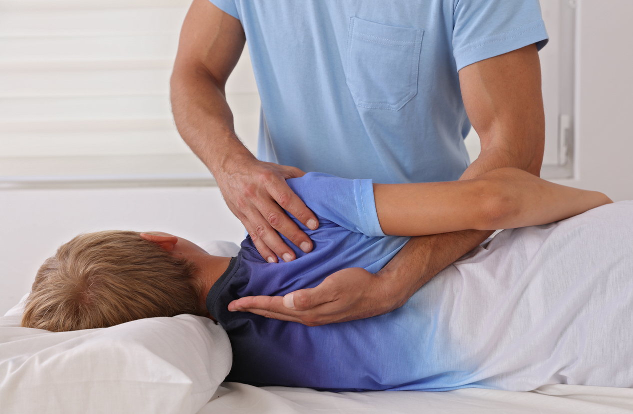 A person massaging a child's back, When Your Child Needs a Chiropractor