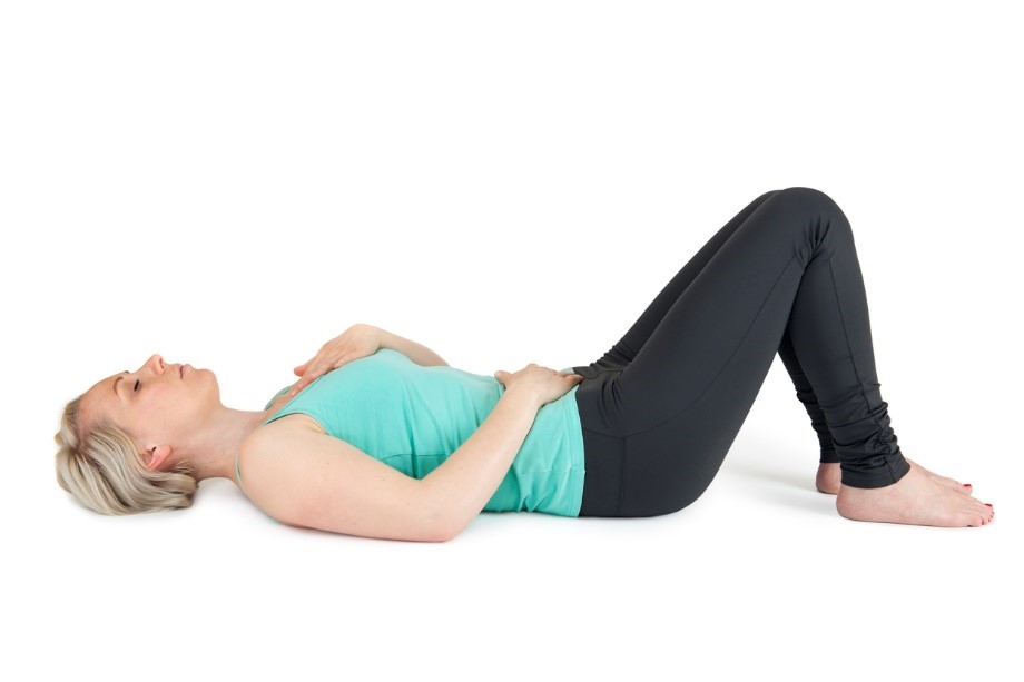 A person lying on the floor, belly breathing