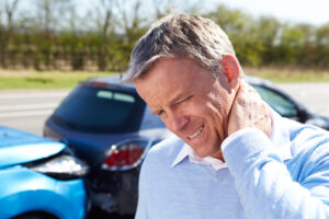 Car Accident Injury Treatment | Serving South Carolina & Southern North Carolina, A person with a sore neck holding their neck after a car accident