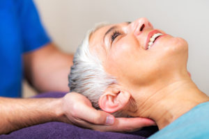 Physical Therapist Working with Neck. Senior Woman