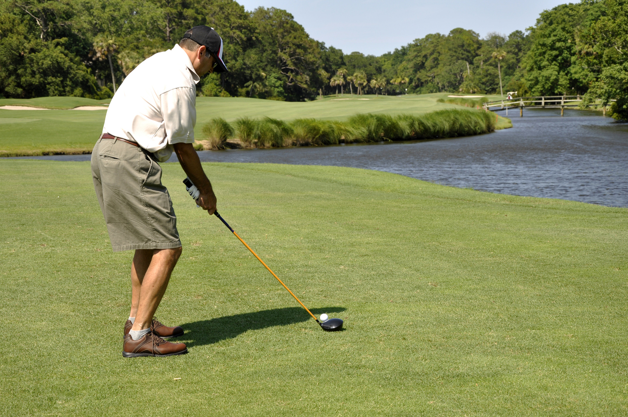 Staying in the Game: How Chiropractic Care Supports Summer Athletes of All Ages, An older man playing gold on a beautiful course with a water hazzard