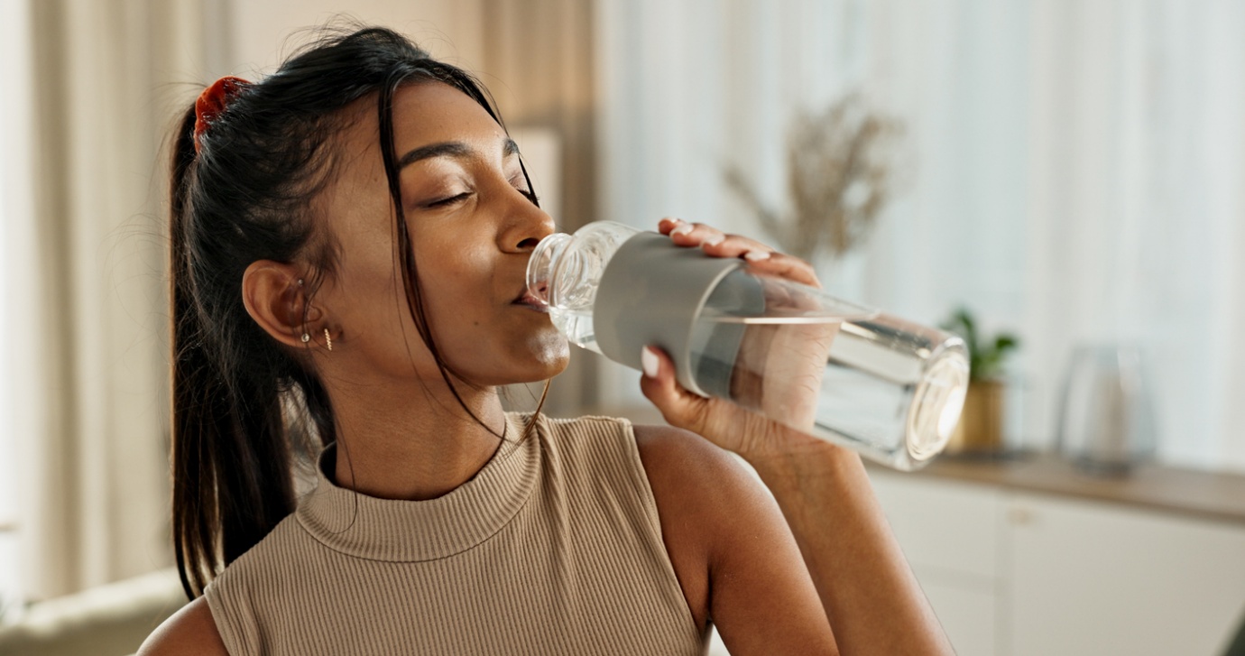 chiropractic care for summer sports, A beautiful woman drinking water from a bottle