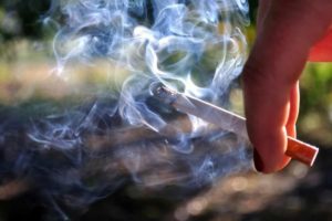 a cigarette in a mans hand