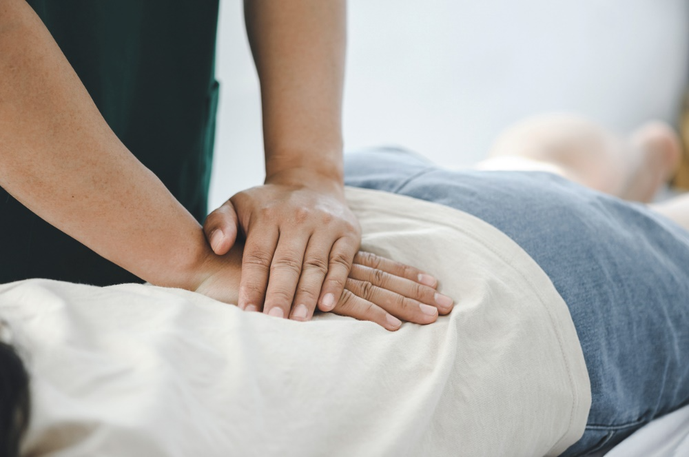 Chiropractor performing a chiropractic adjustment on a patient&rsquo;s lower back to improve movement and reduce stiffness