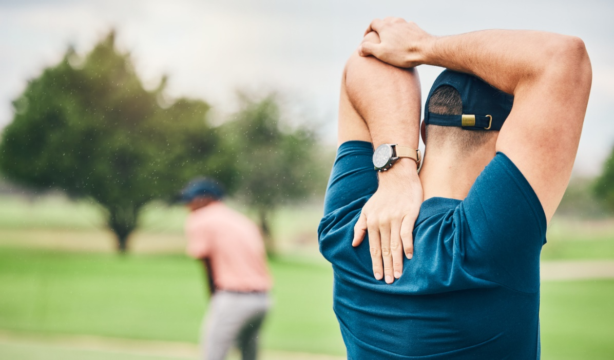 Man stretching his shoulder before playing golf to warm up and support mobility