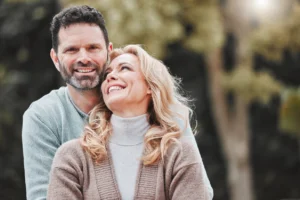 Smiling middle-aged couple outdoors representing pelvic floor health, confidence, and sexual wellness for men and women.