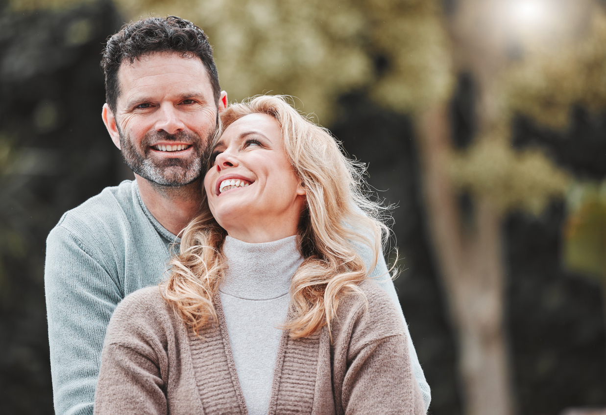 Smiling middle-aged couple outdoors representing pelvic floor health, confidence, and sexual wellness for men and women.