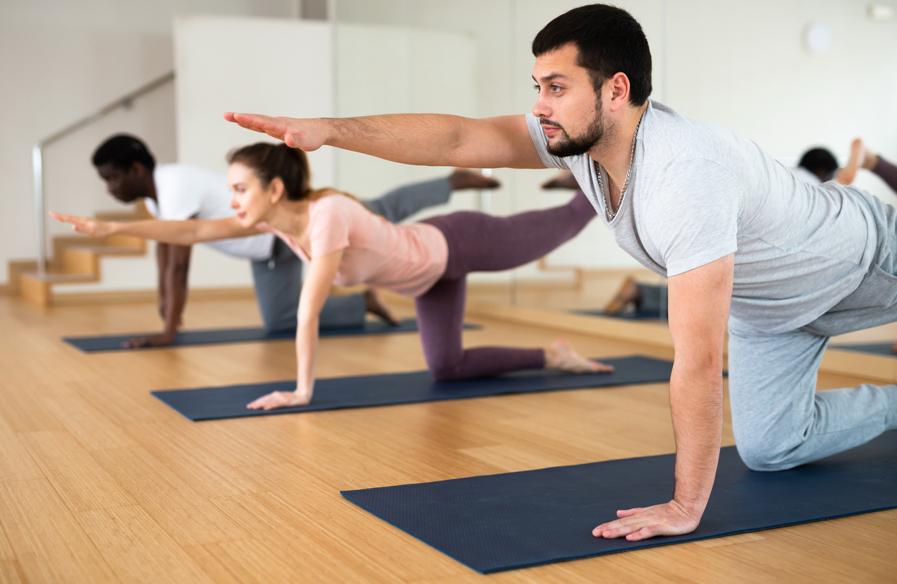 Man performing a bird dog exercise to strengthen the muscles that support the back and spine